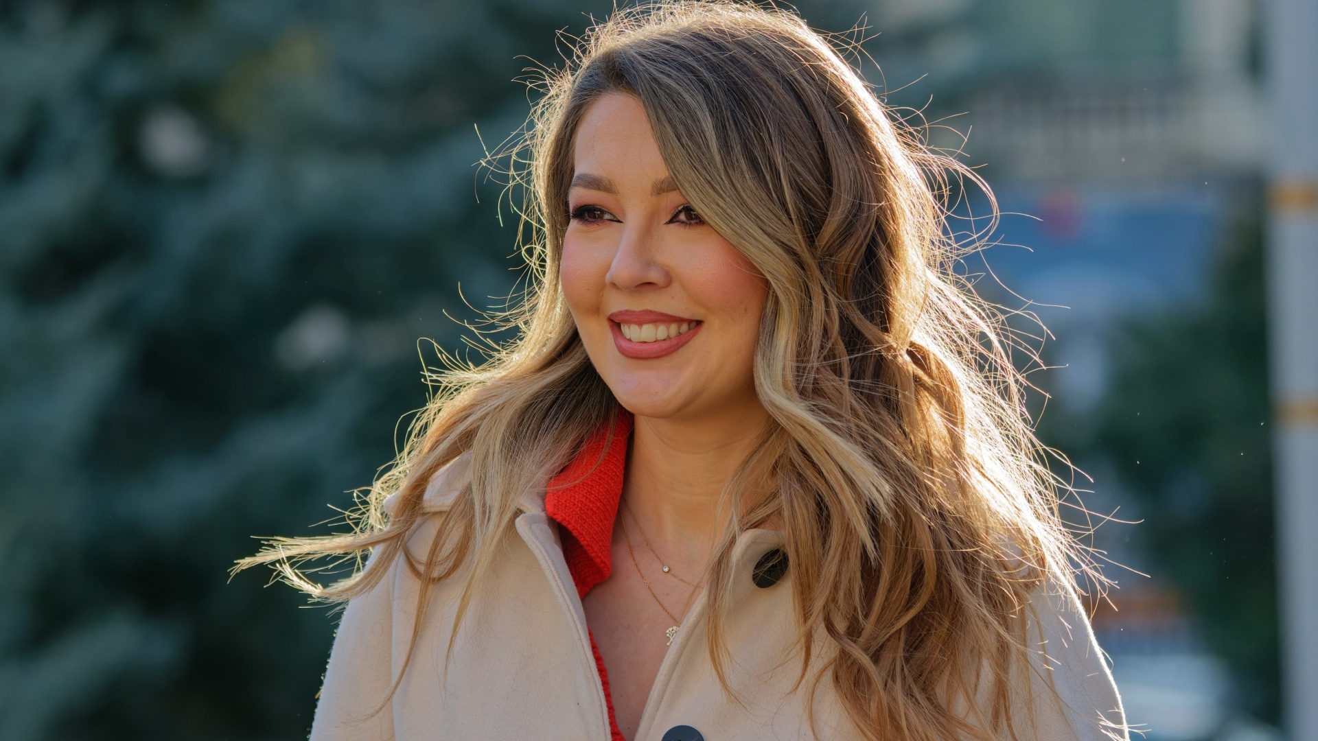 Женщина с милой улыбкой в пальто на улице