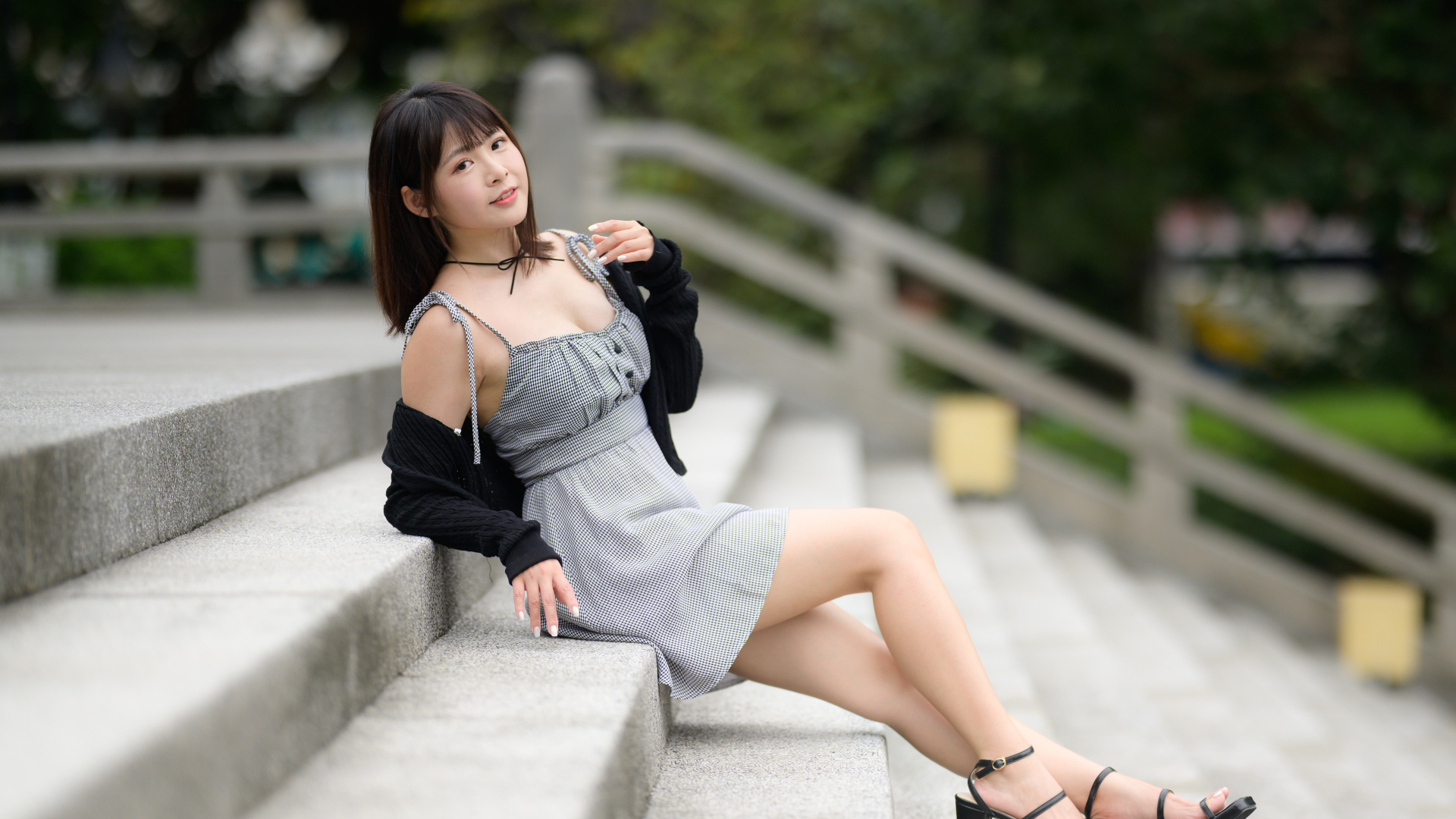 Молодая азиатка в платье лежит на ступеньках