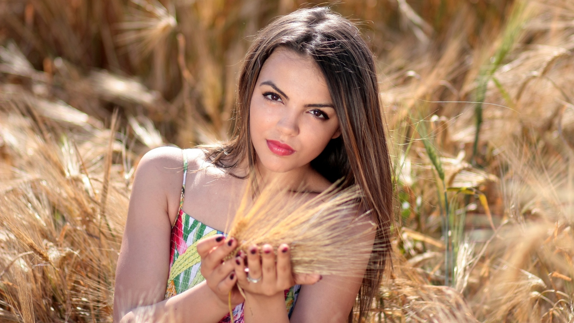 Молодая красивая девушка с колосьями пшеницы в руках