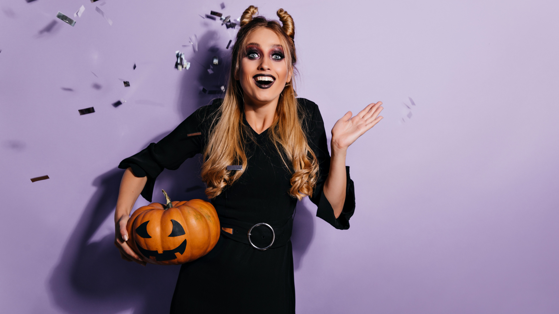 Девушка в черном костюме с тыквой на праздник Хэллоуин