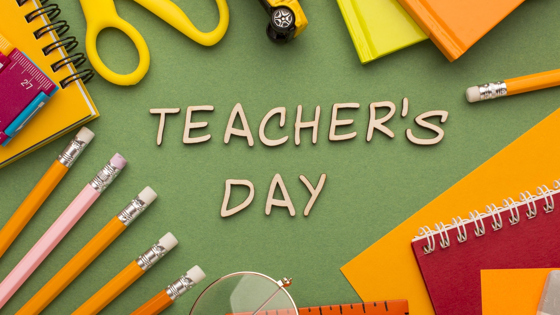 Канцелярские предметы на зеленом столе на день учителя