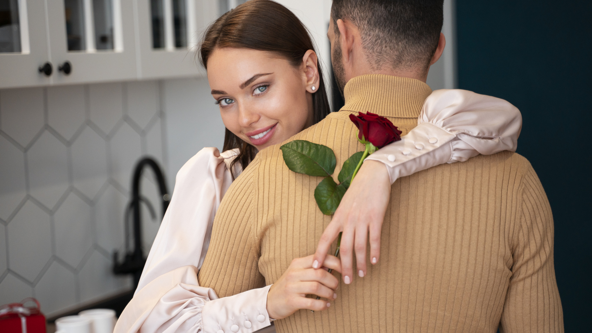 Влюбленная девушка с розой обнимает парня