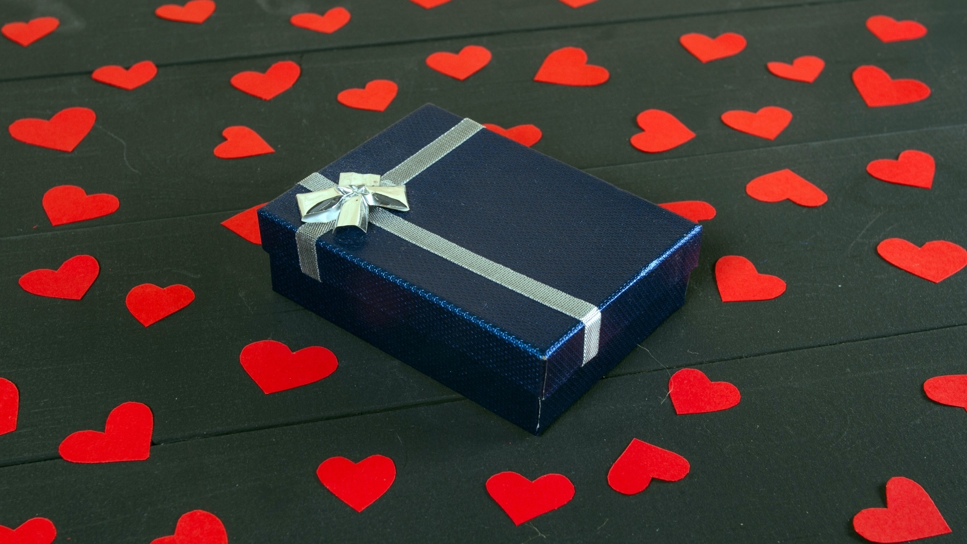 Черная коробка с красными сердечками на столе