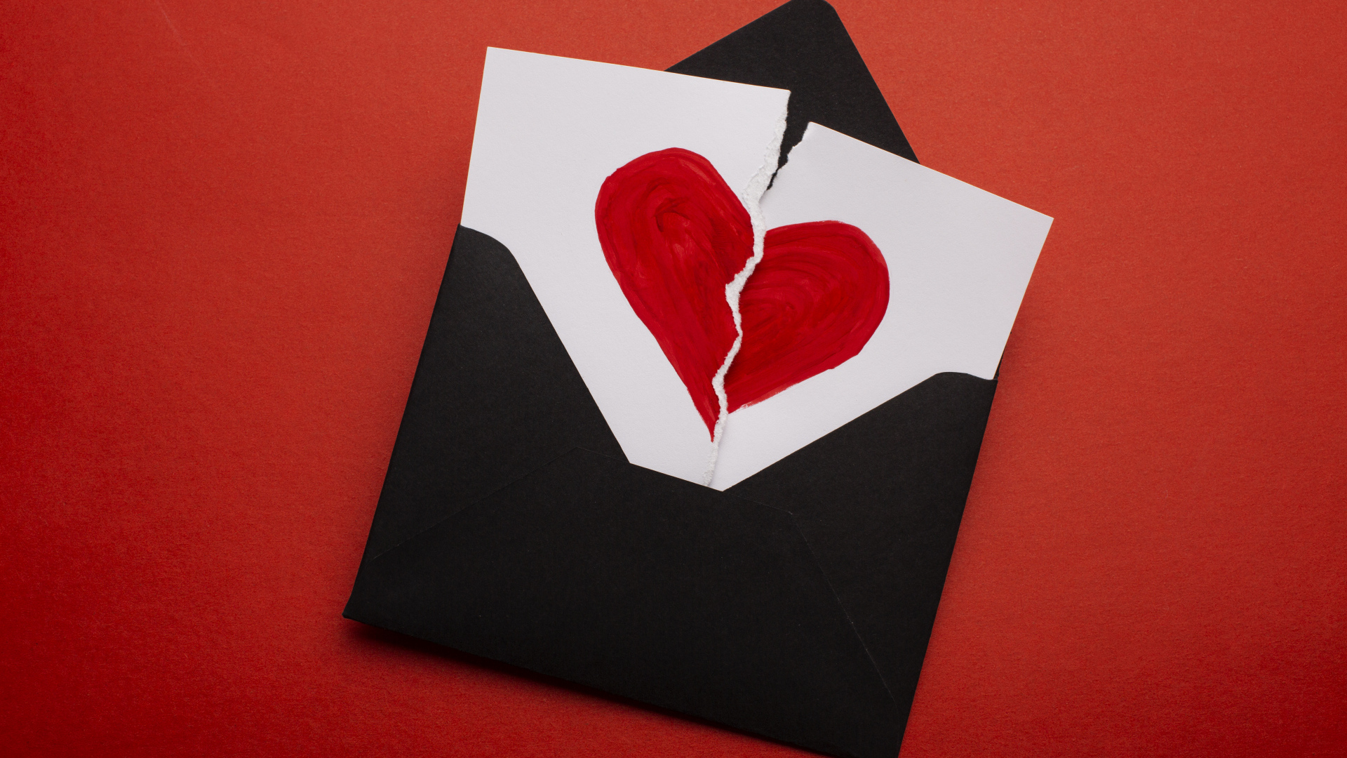 Черный конверт с нарисованным разбитым сердцем