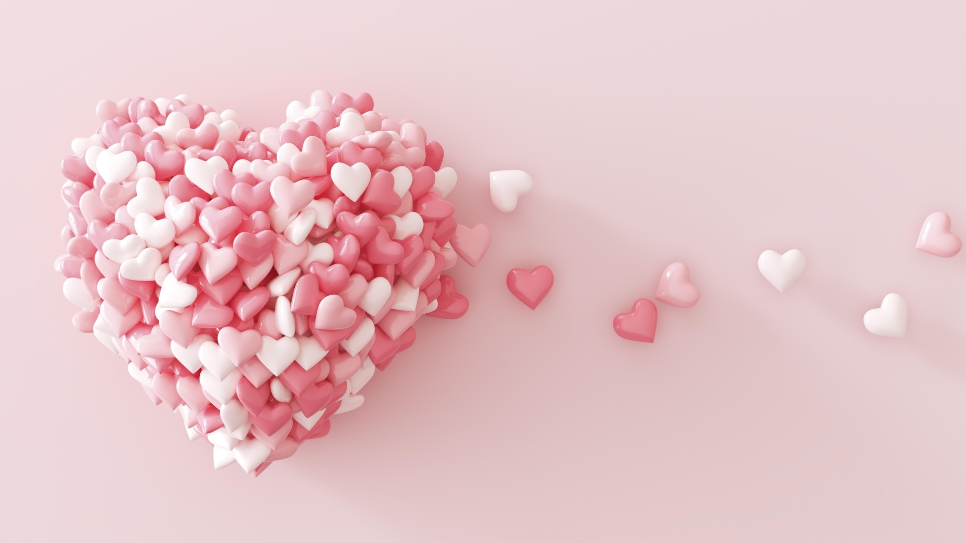 Сердце из маленьких сердечек на розовом фоне