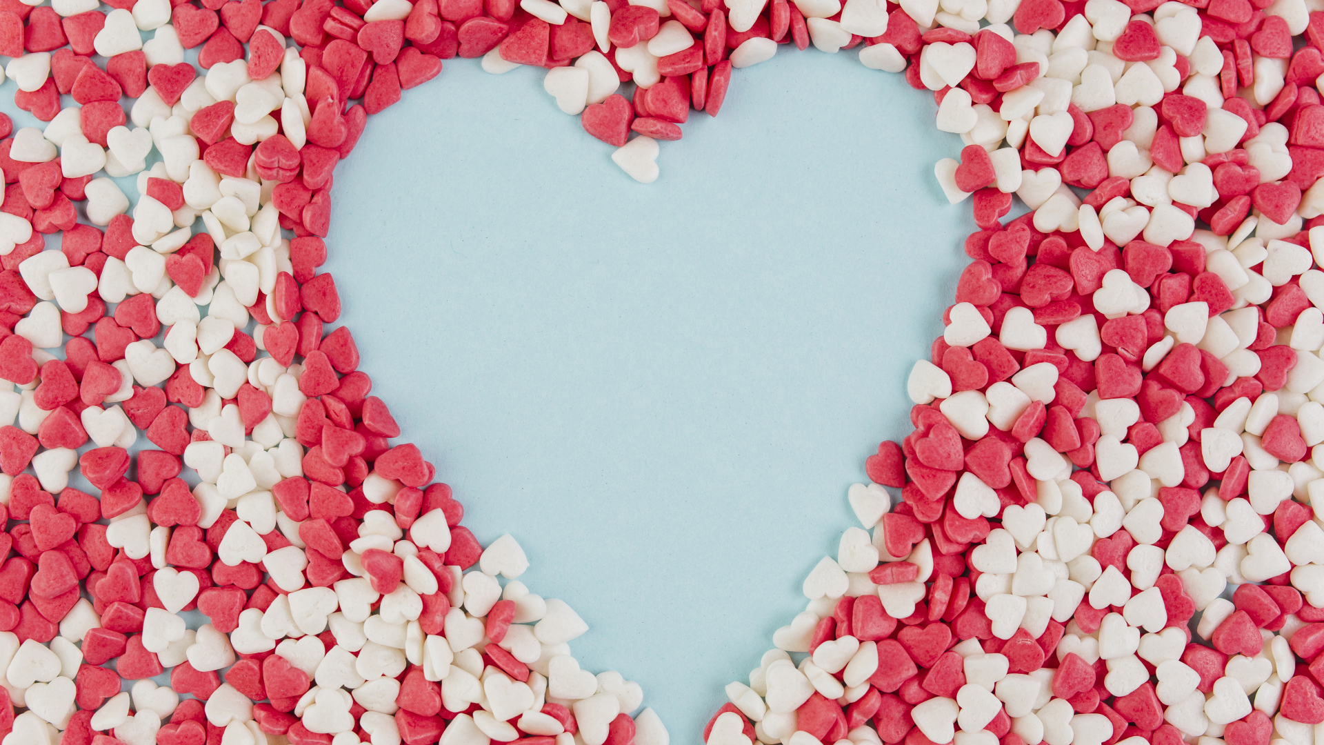 Сердце на голубом фоне из маленьких сладких сердечек