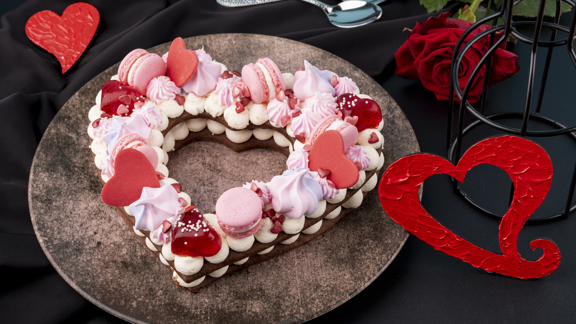 Десерт в форме сердца на столе с красной розой