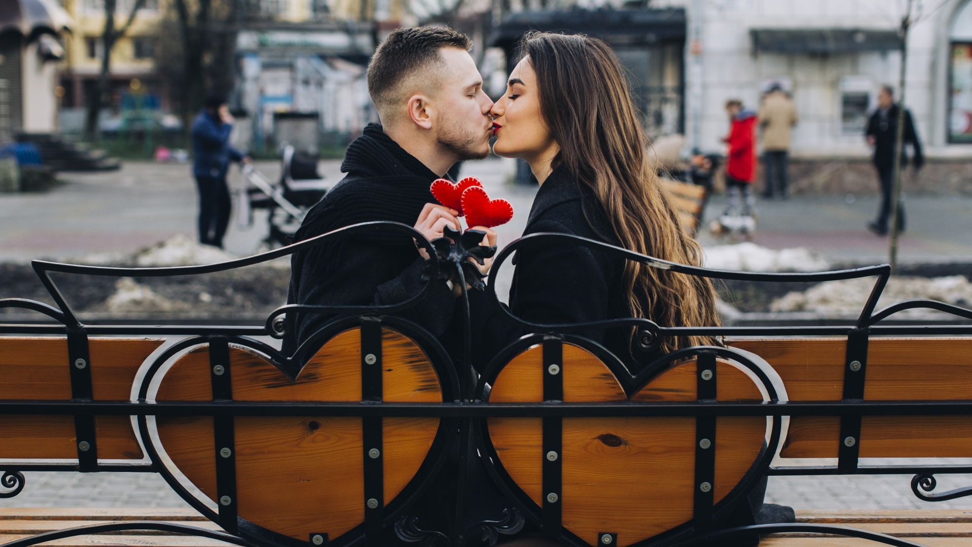 Поцелуй влюбленной пары на лавке в парке