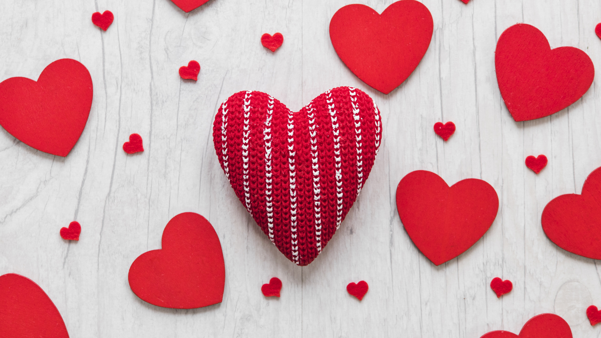 Много красных сердец на белом деревянном столе
