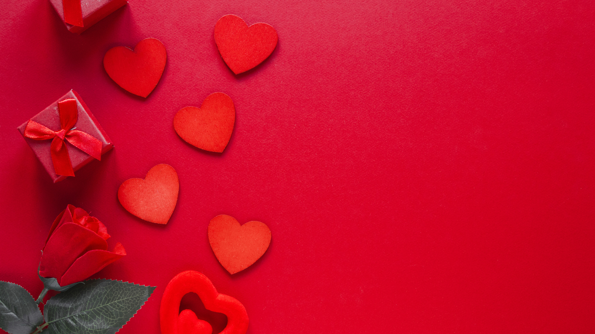Бумажные сердечки с подарком и розой на красном фоне