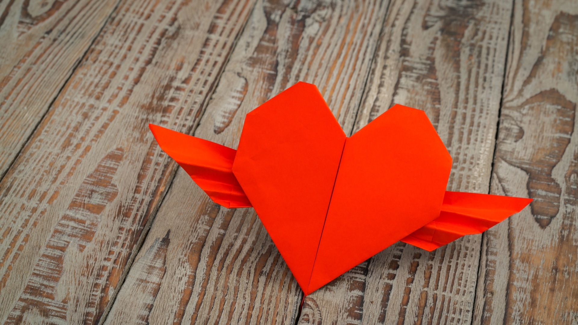 Бумажное красное сердце на деревянных досках