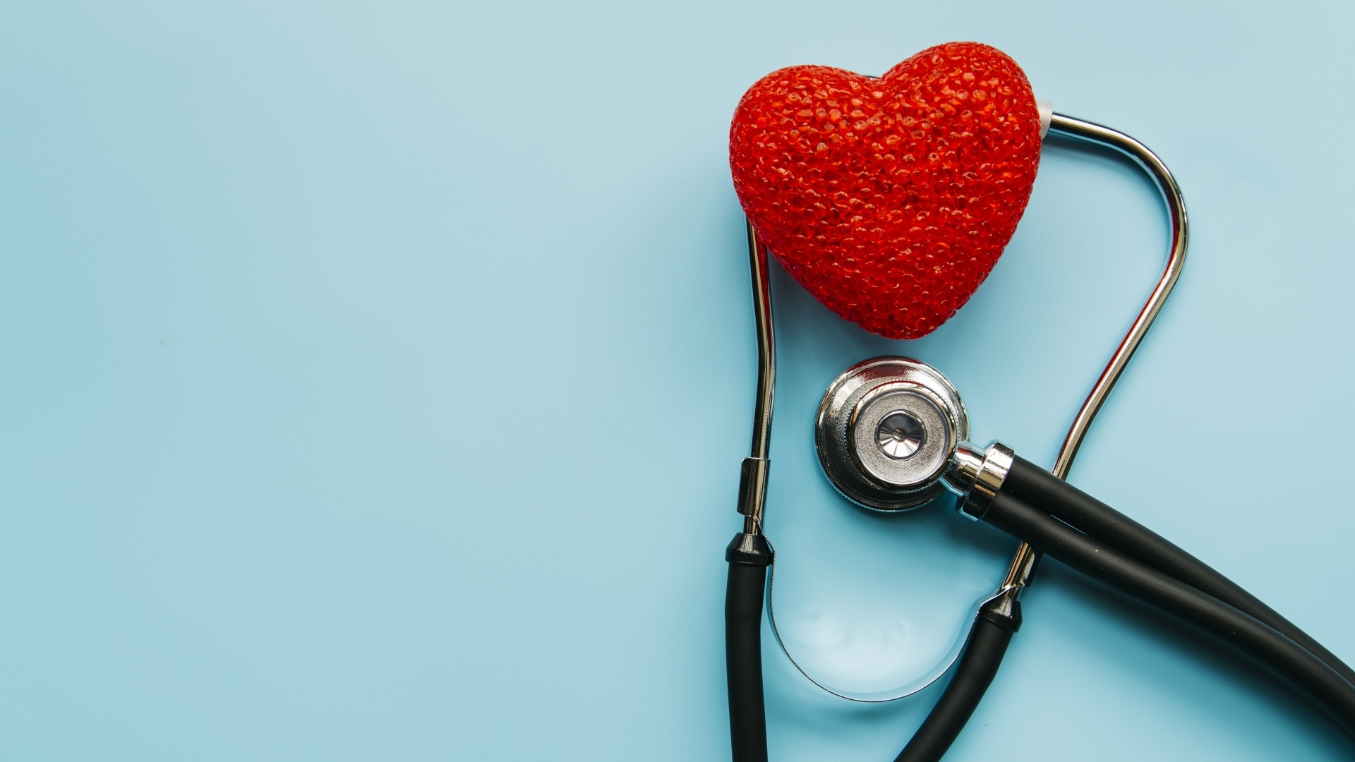 Красное сердце с стетоскопом на голубом фоне