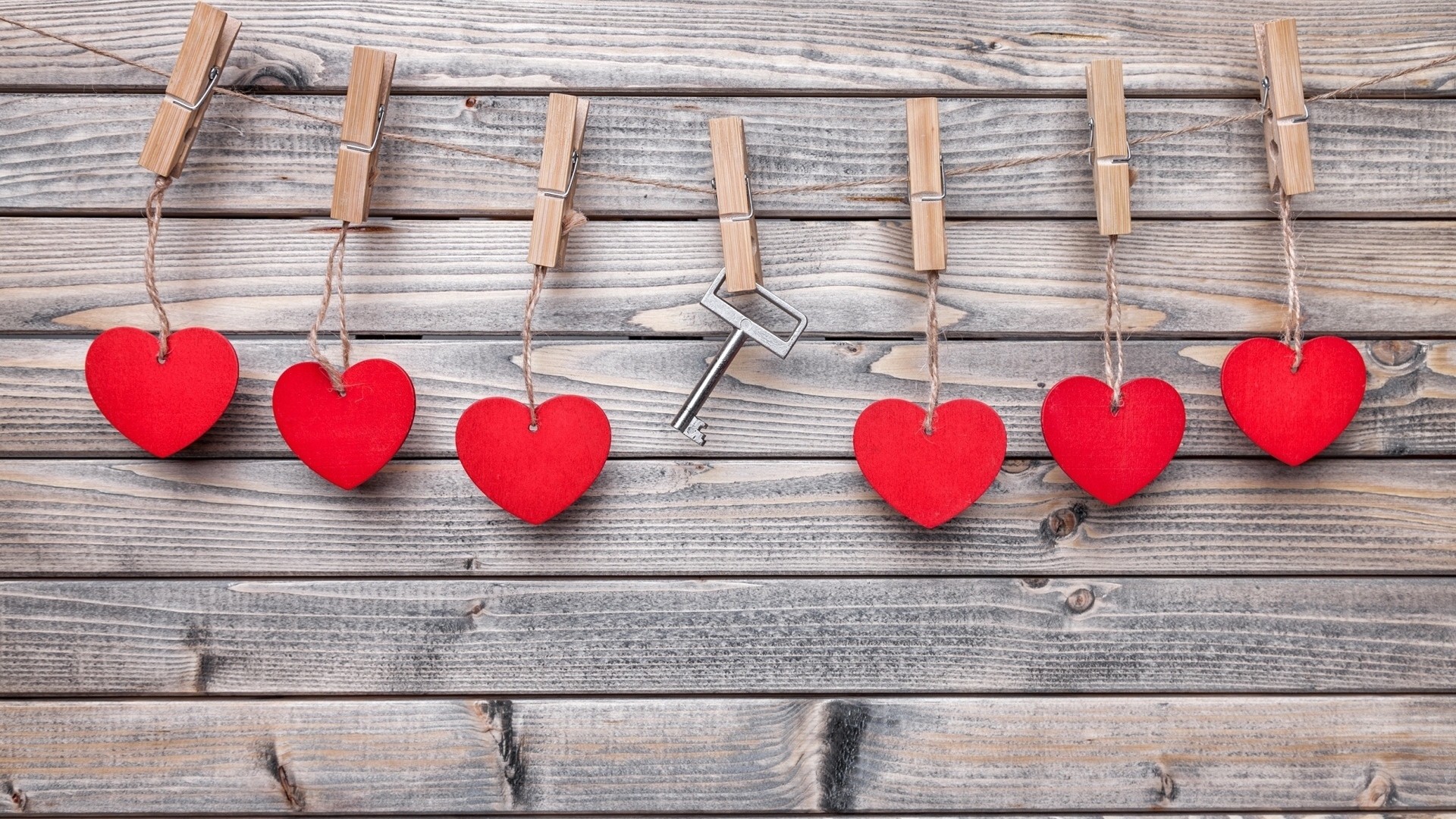 Красные сердечки и ключ с прищепками на веревке