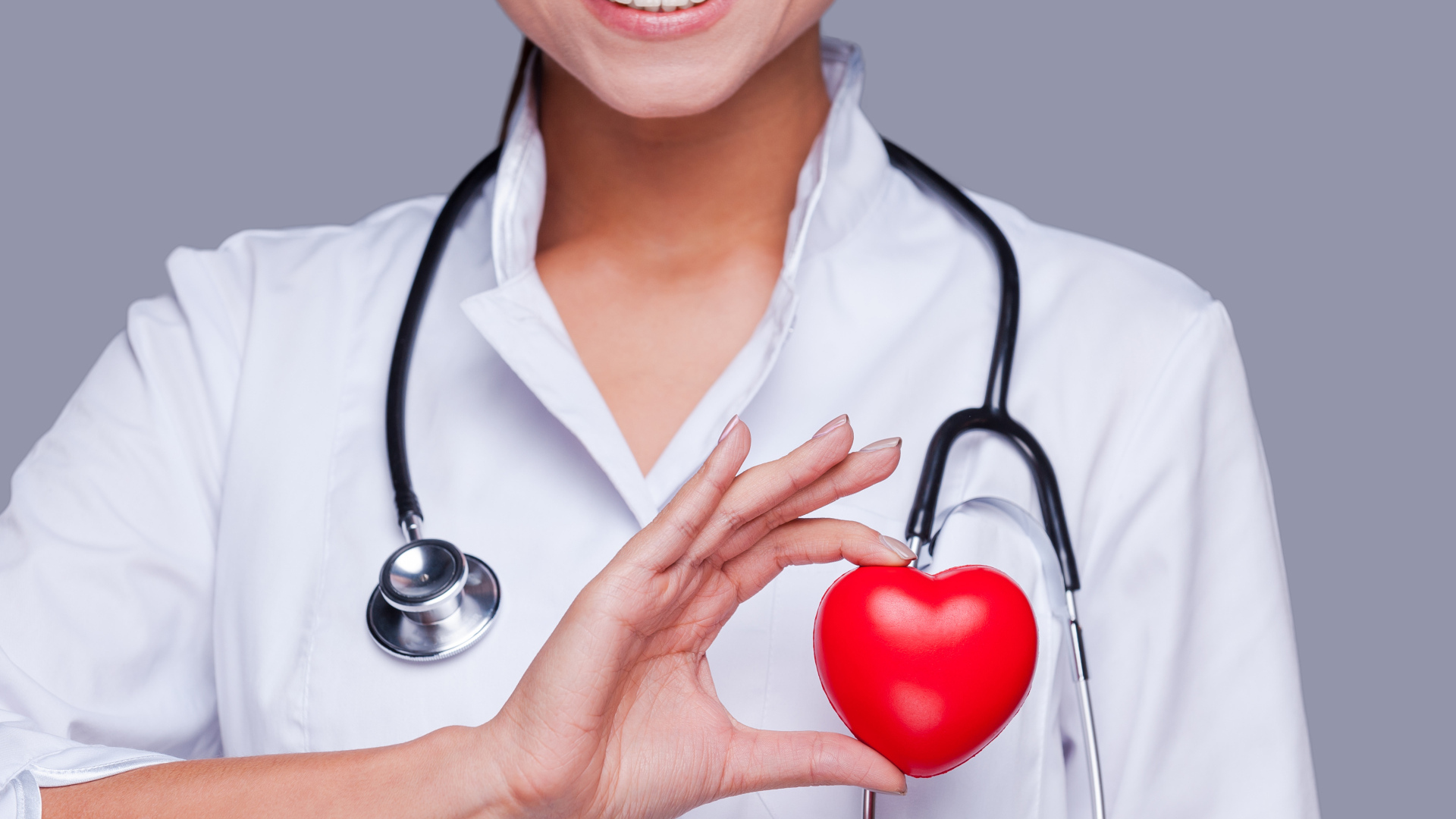 Улыбающаяся женщина врач с красным сердцем