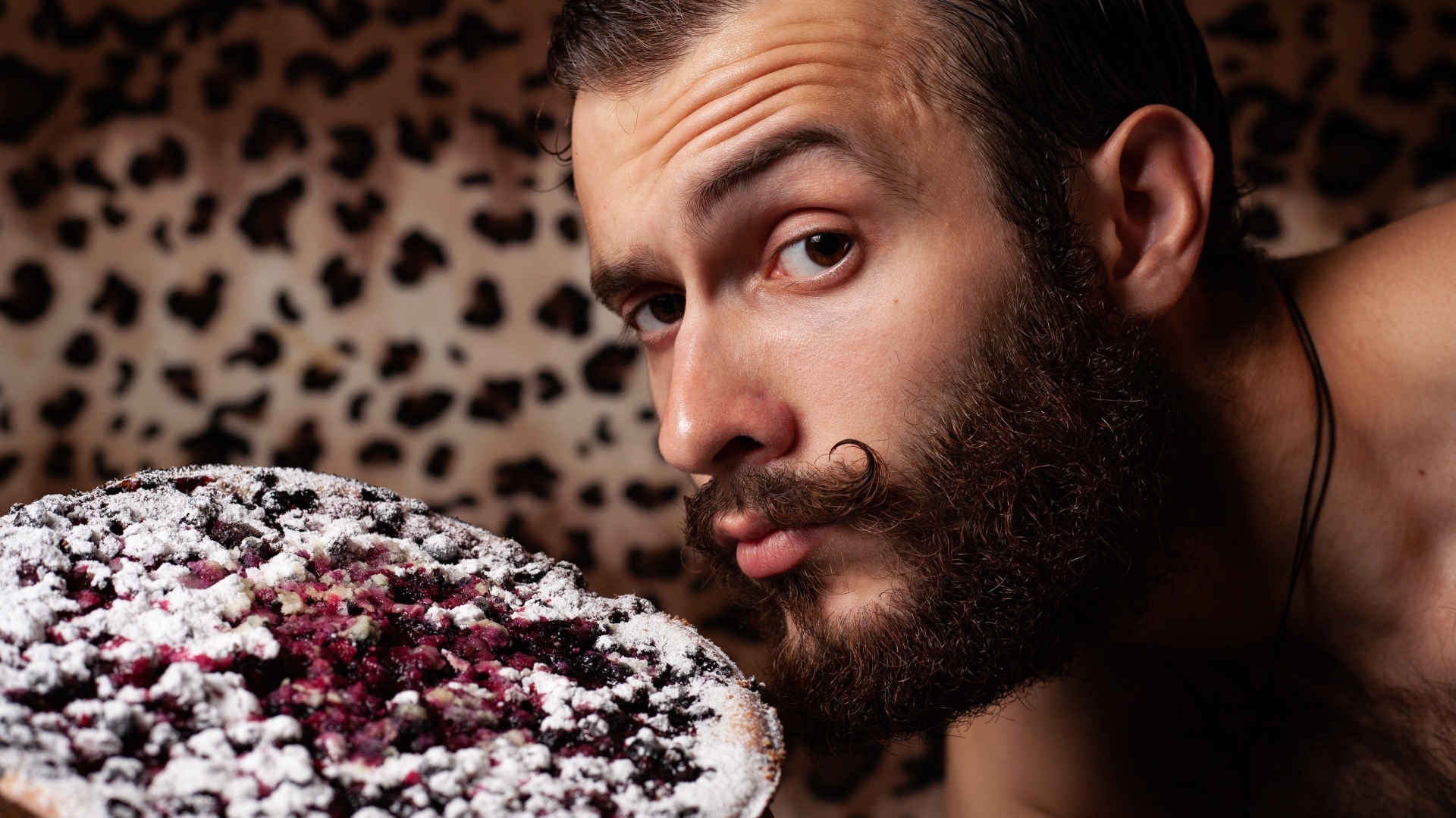 Мужчина с бородой держит сладкий пирог 