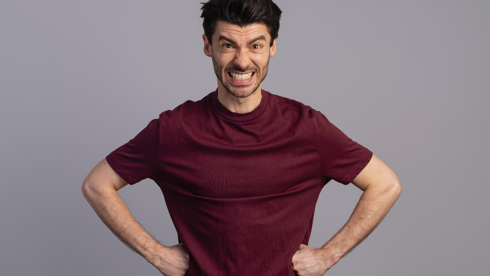 Злой мужчина на сером фоне