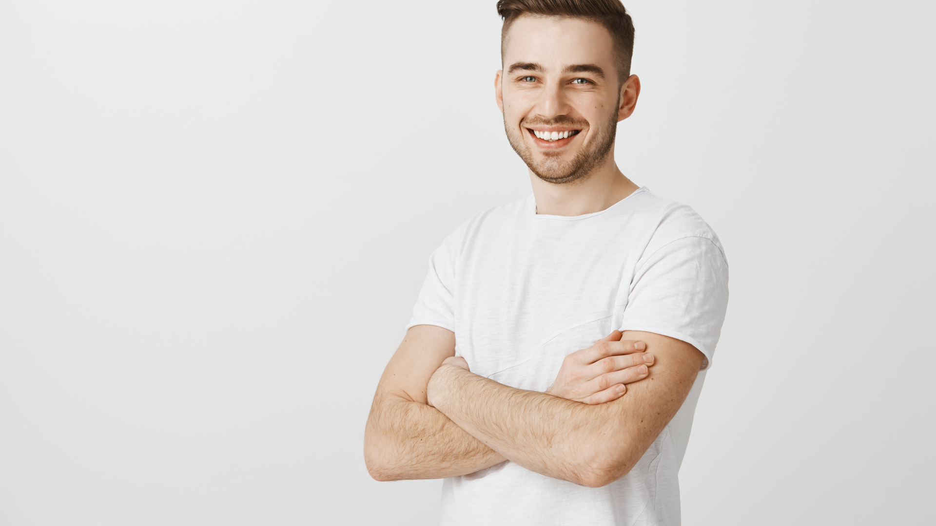 Улыбающийся молодой человек с белой футболке