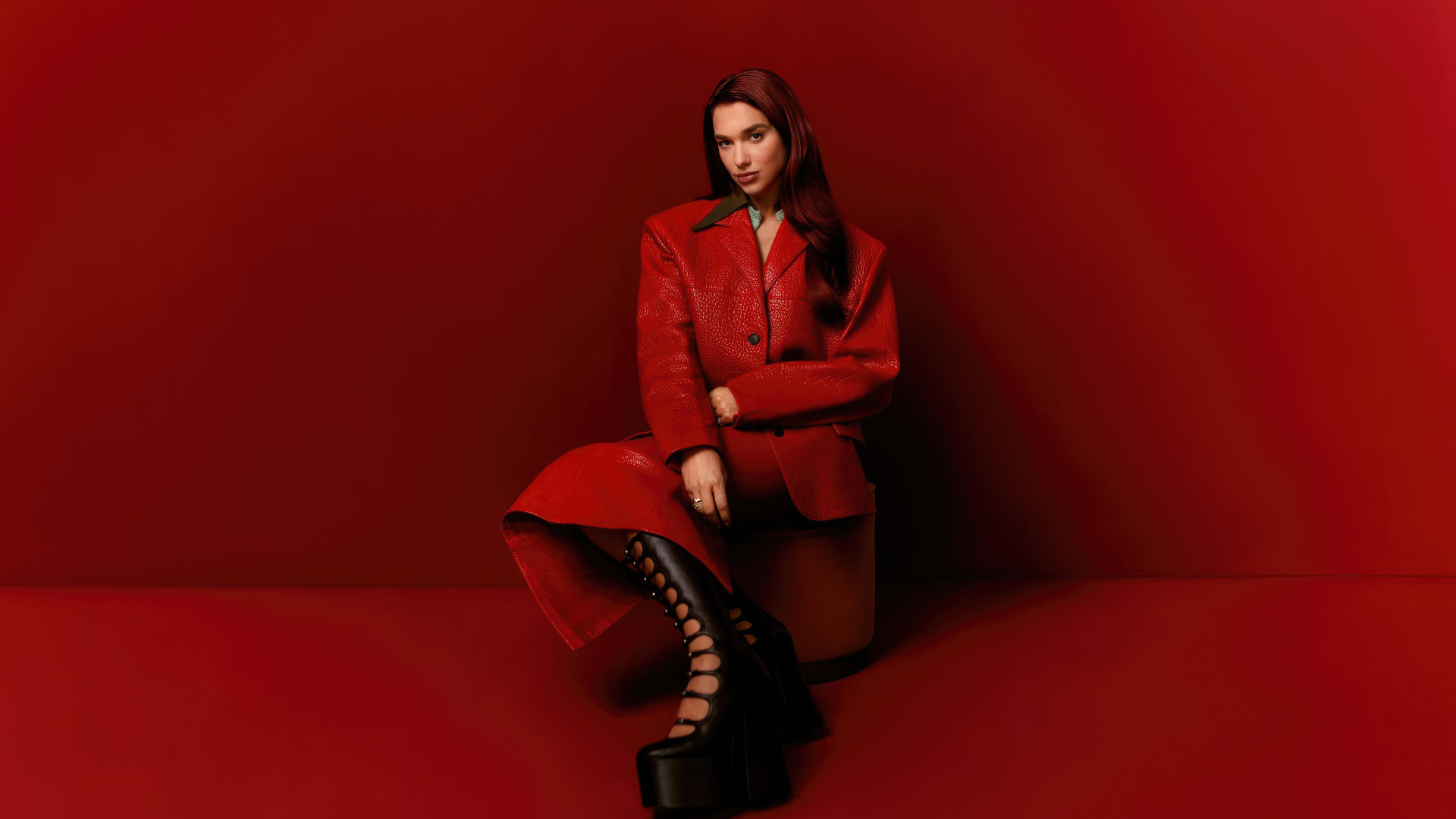 Британская певица Дуа Липа на красном фоне