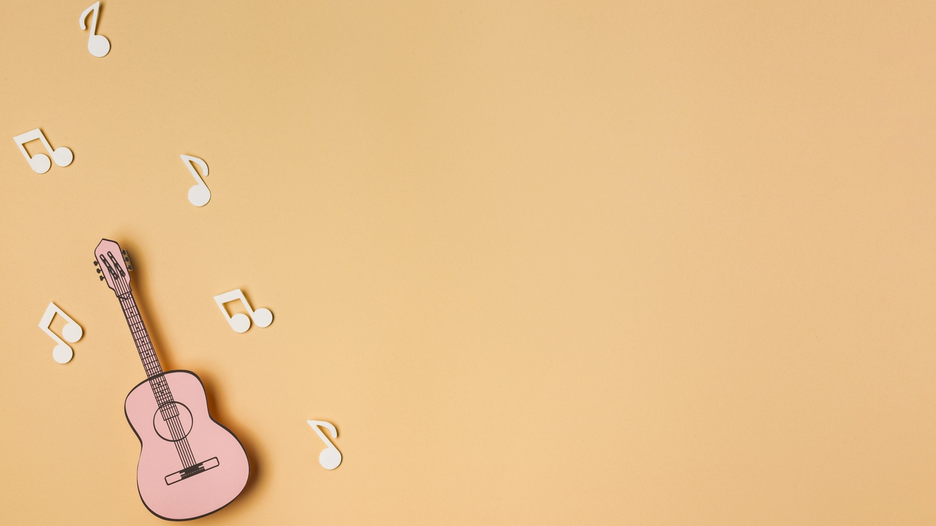 Бумажная гитара и ноты на бежевом фоне
