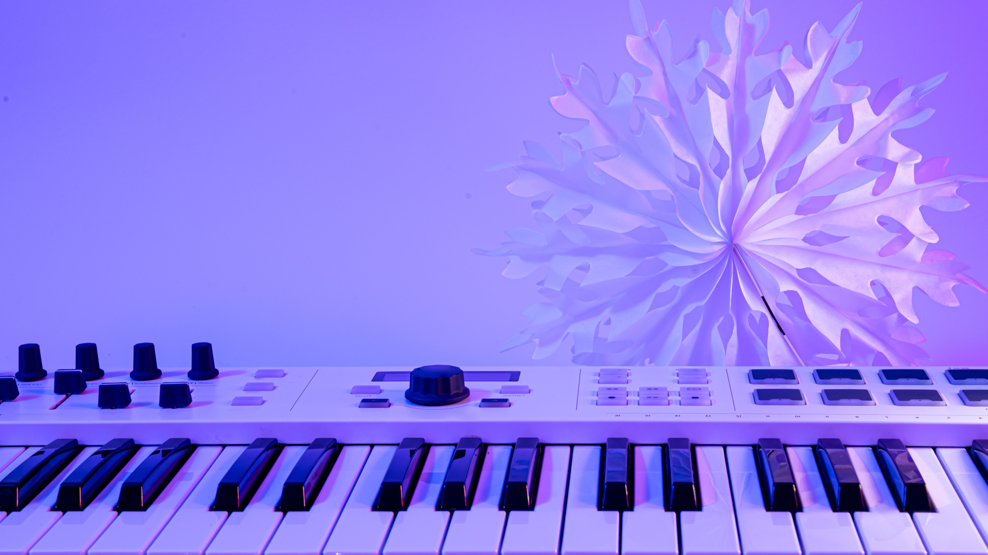 Синтезатор с бумажной снежинкой на фиолетовом фоне