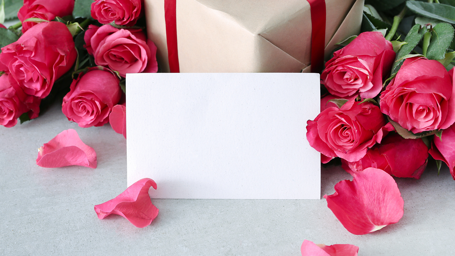 Лист бумаги с розовыми розами и подарком для открытки