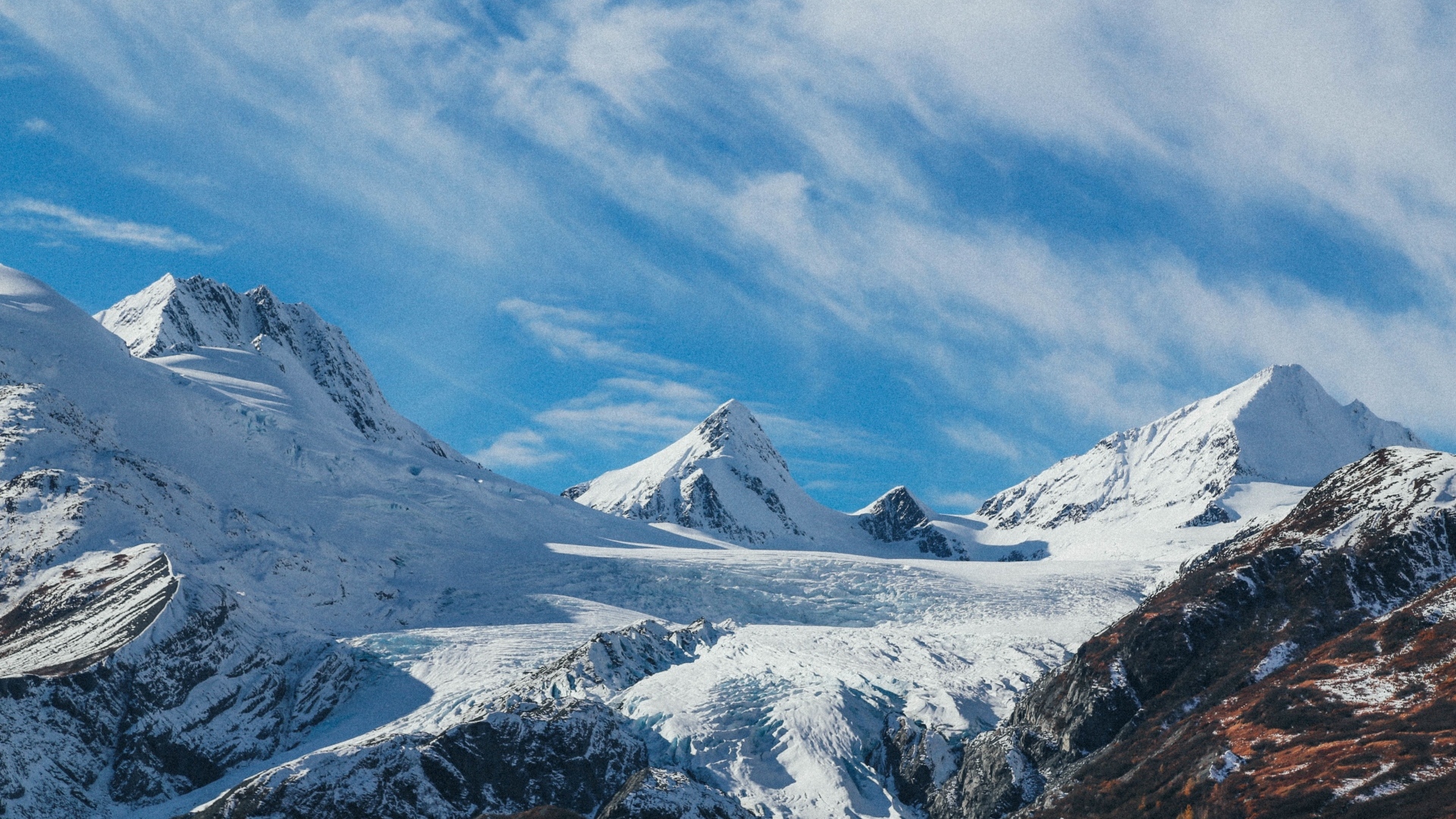 Высокие заснеженные горы под голубым ясным небом