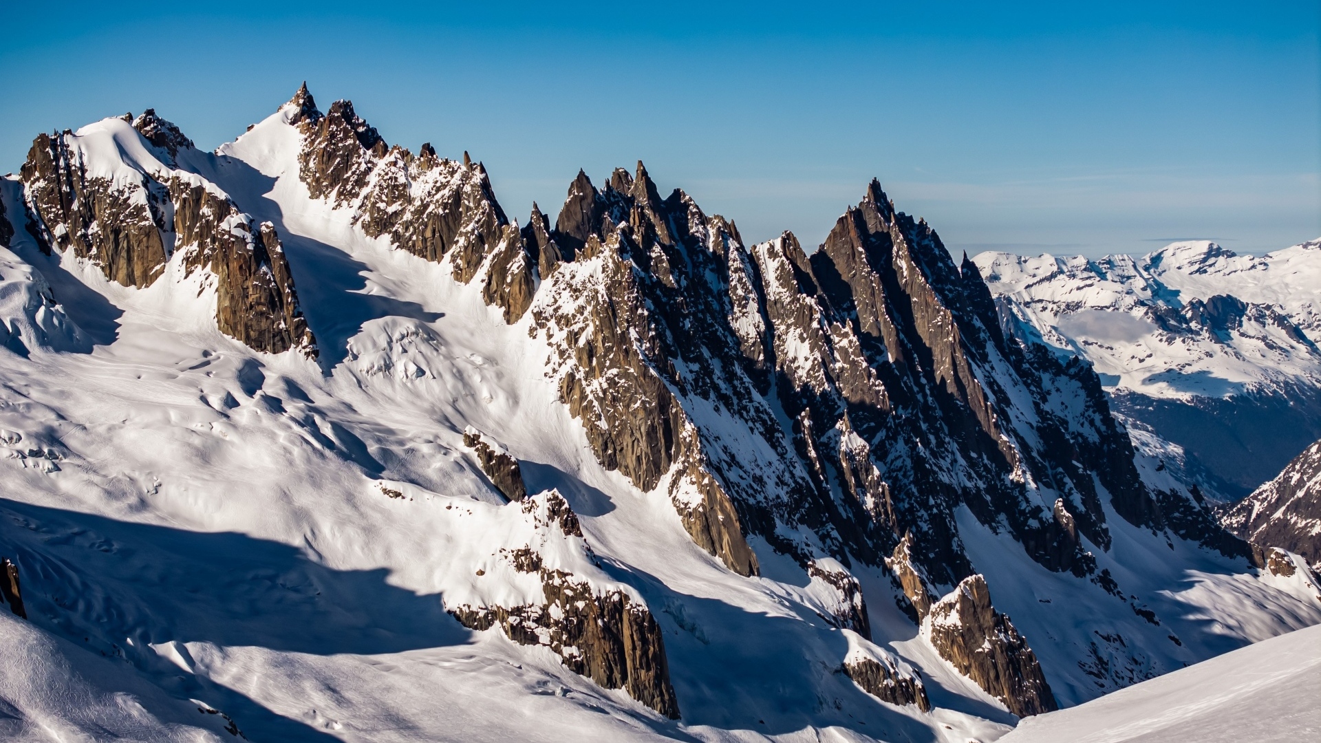 Солнце покрывает заснеженные горы