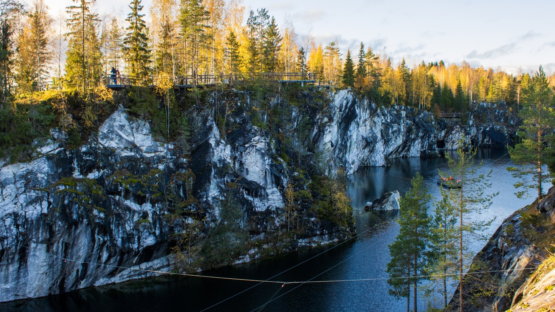 Вид на утес покрытый деревьями у воды