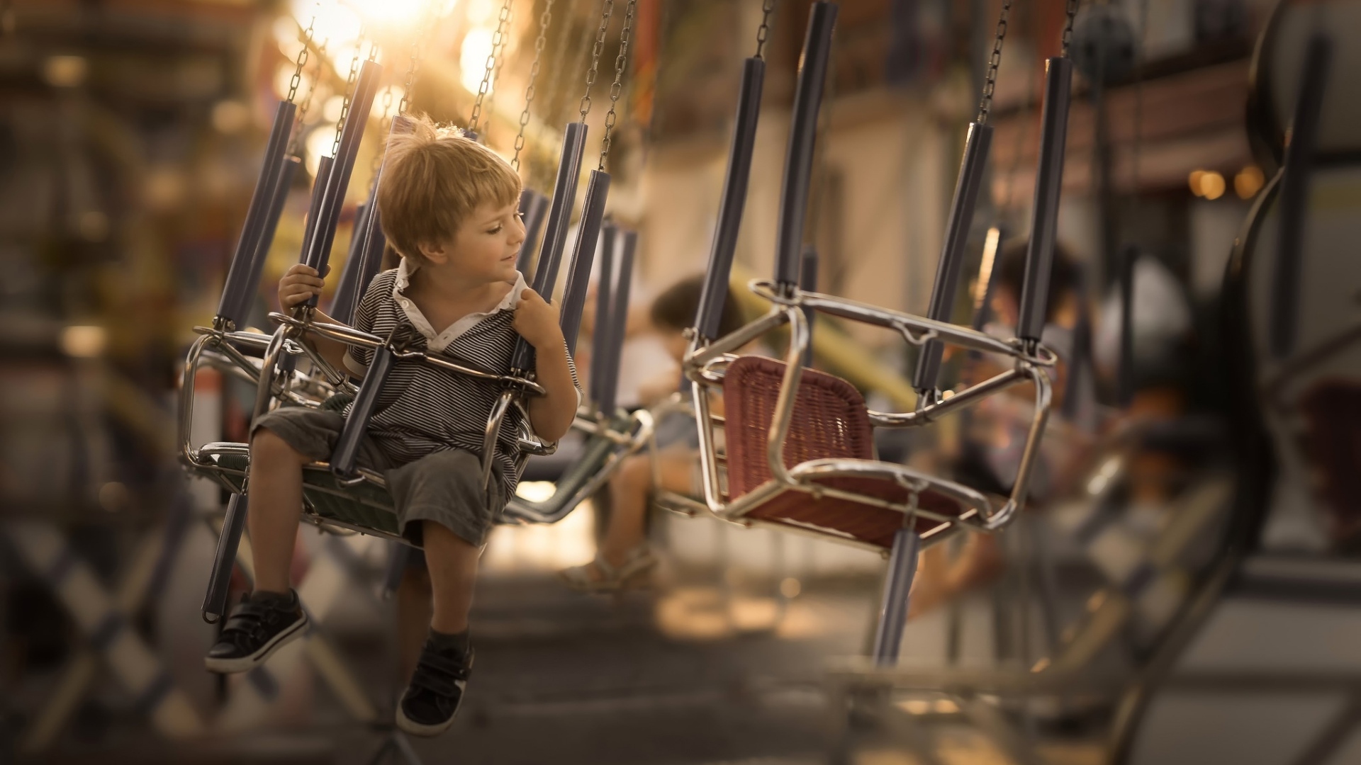 Маленький мальчик катается на каруселях
