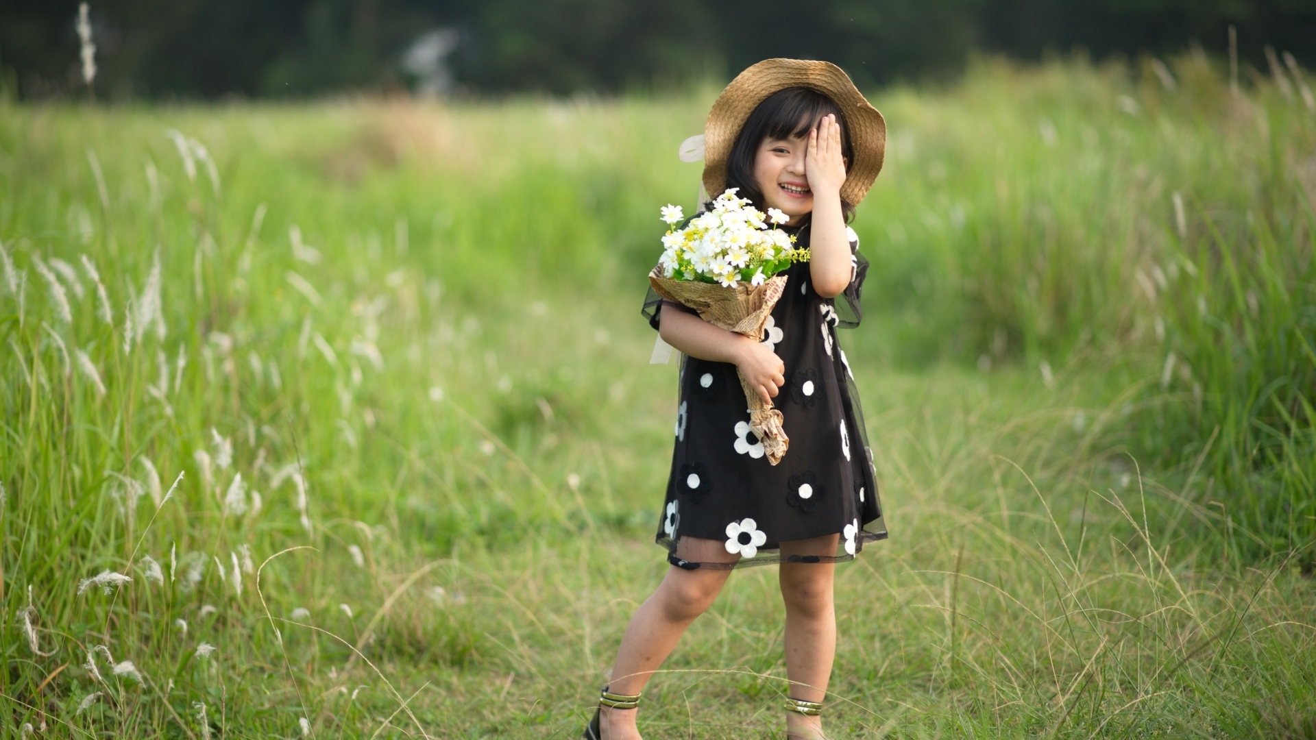 Девочка азиатка в шляпе с букетом цветов