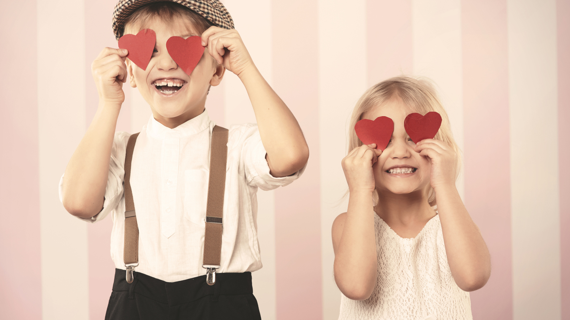 Мальчик и девочка с сердечками в руках