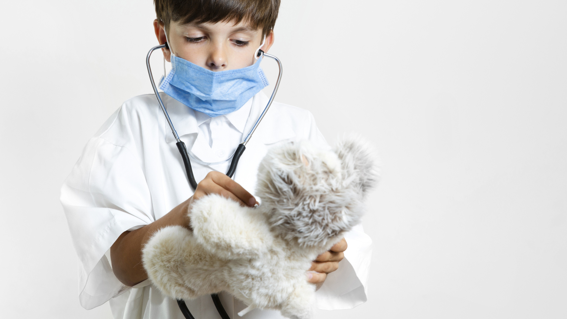 Мальчик в костюме врача с игрушечным медведем