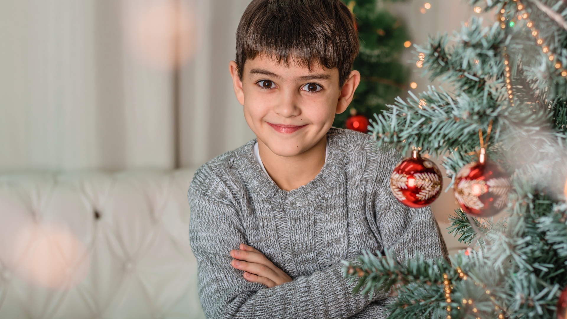 Кареглазый мальчик у новогодней ели