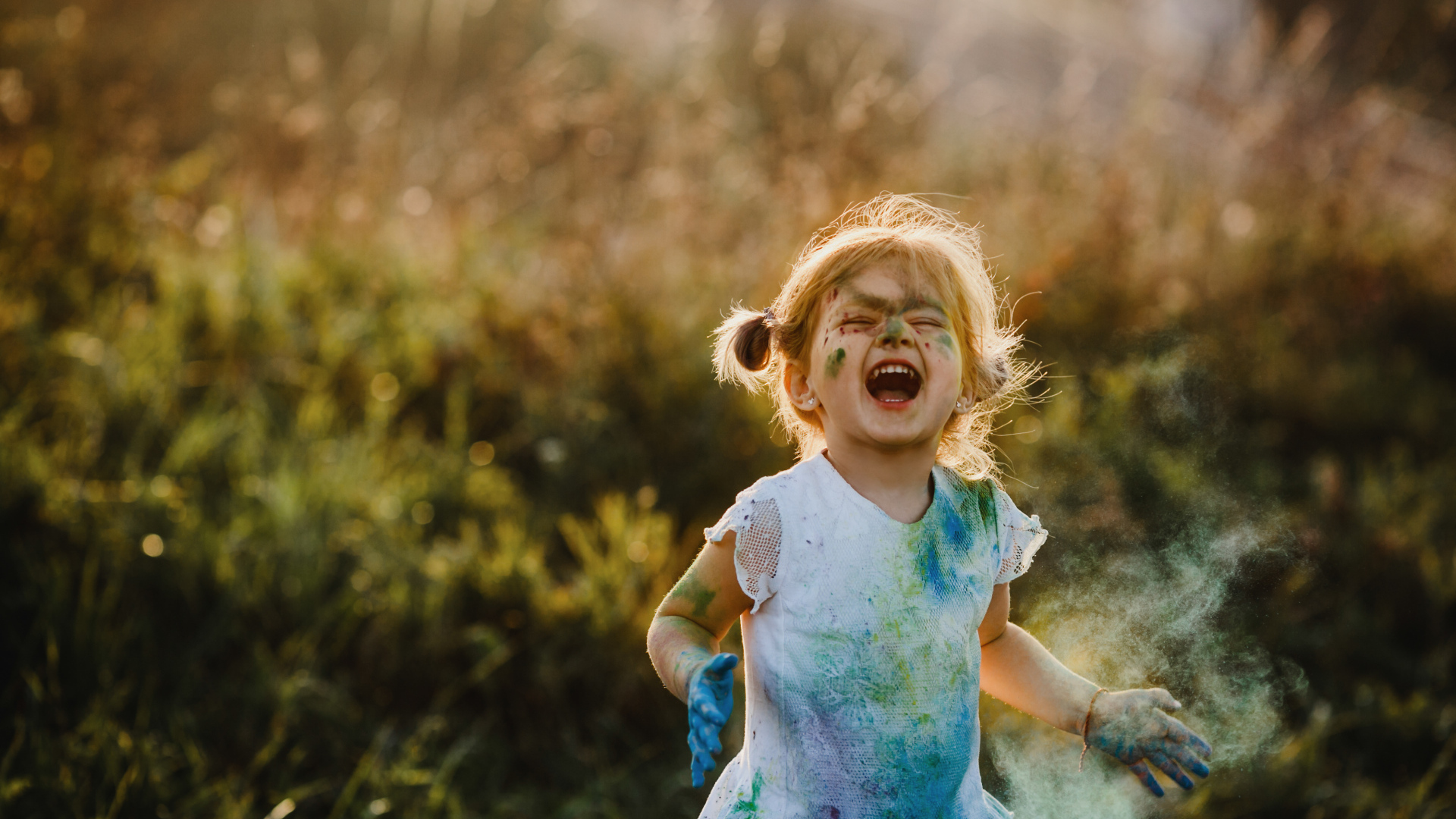 Веселая девочка в краске на улице