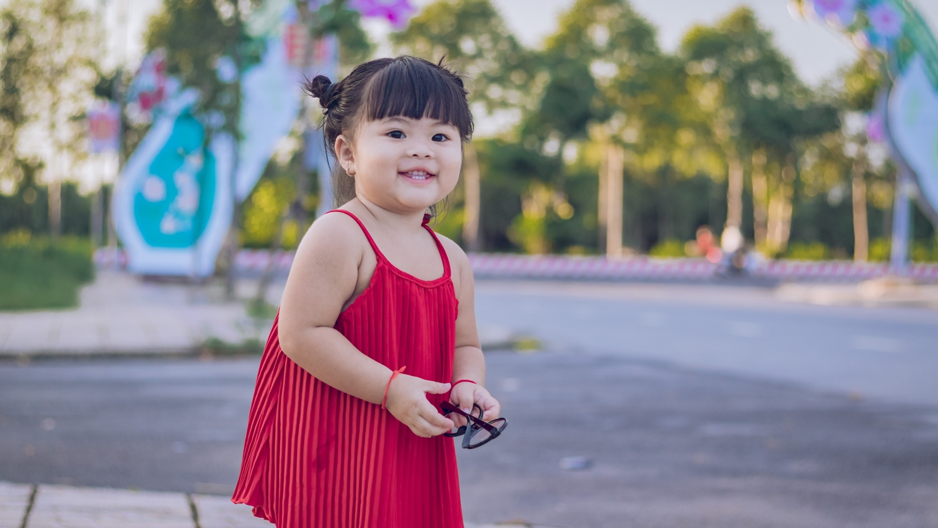 Веселая маленькая девочка азиатка в красном платье