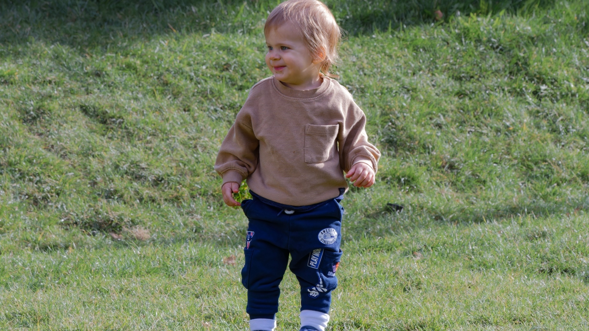 Веселый маленький мальчик гуляет на природе