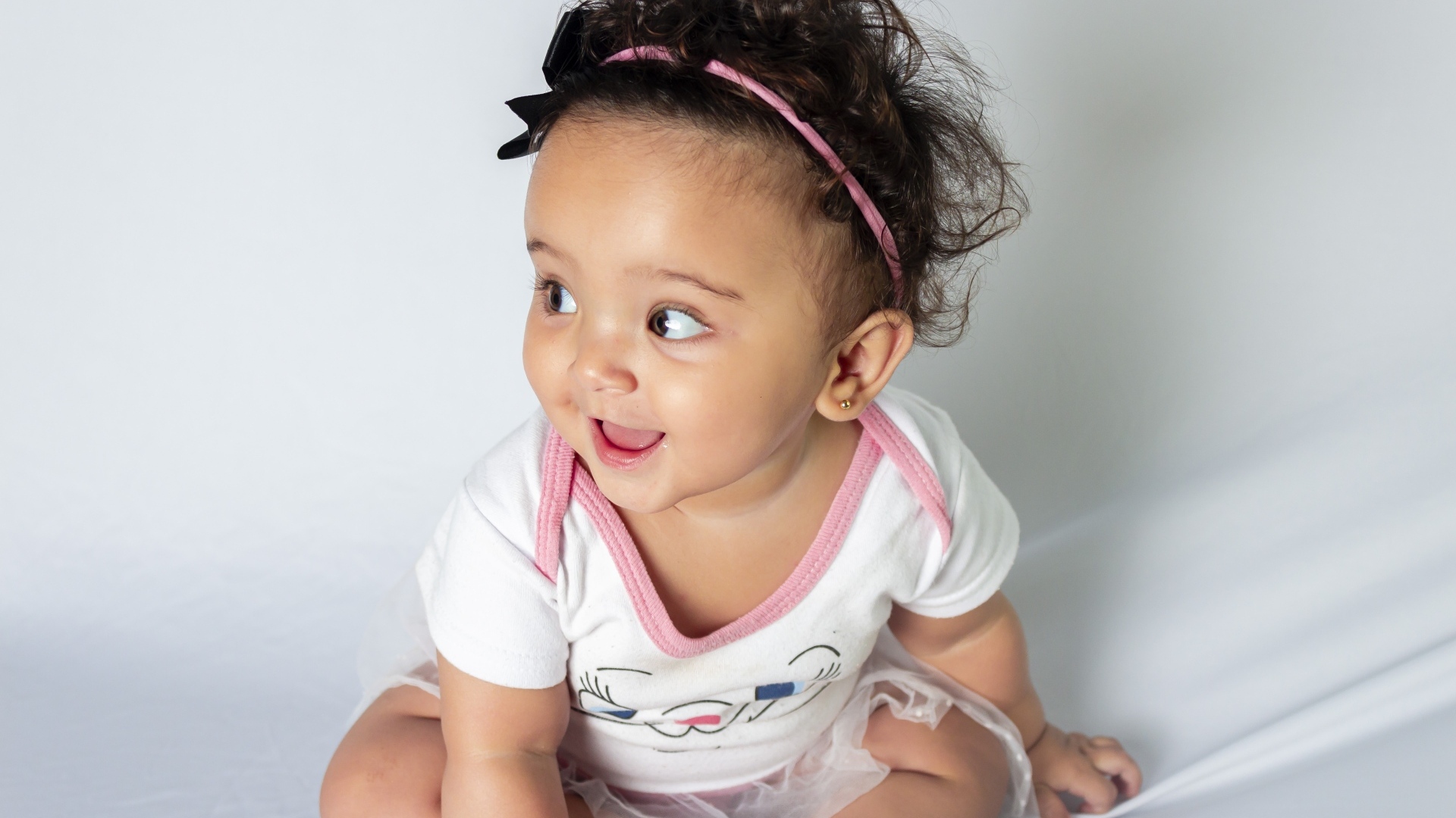 Веселая маленькая девочка с ободком на голове