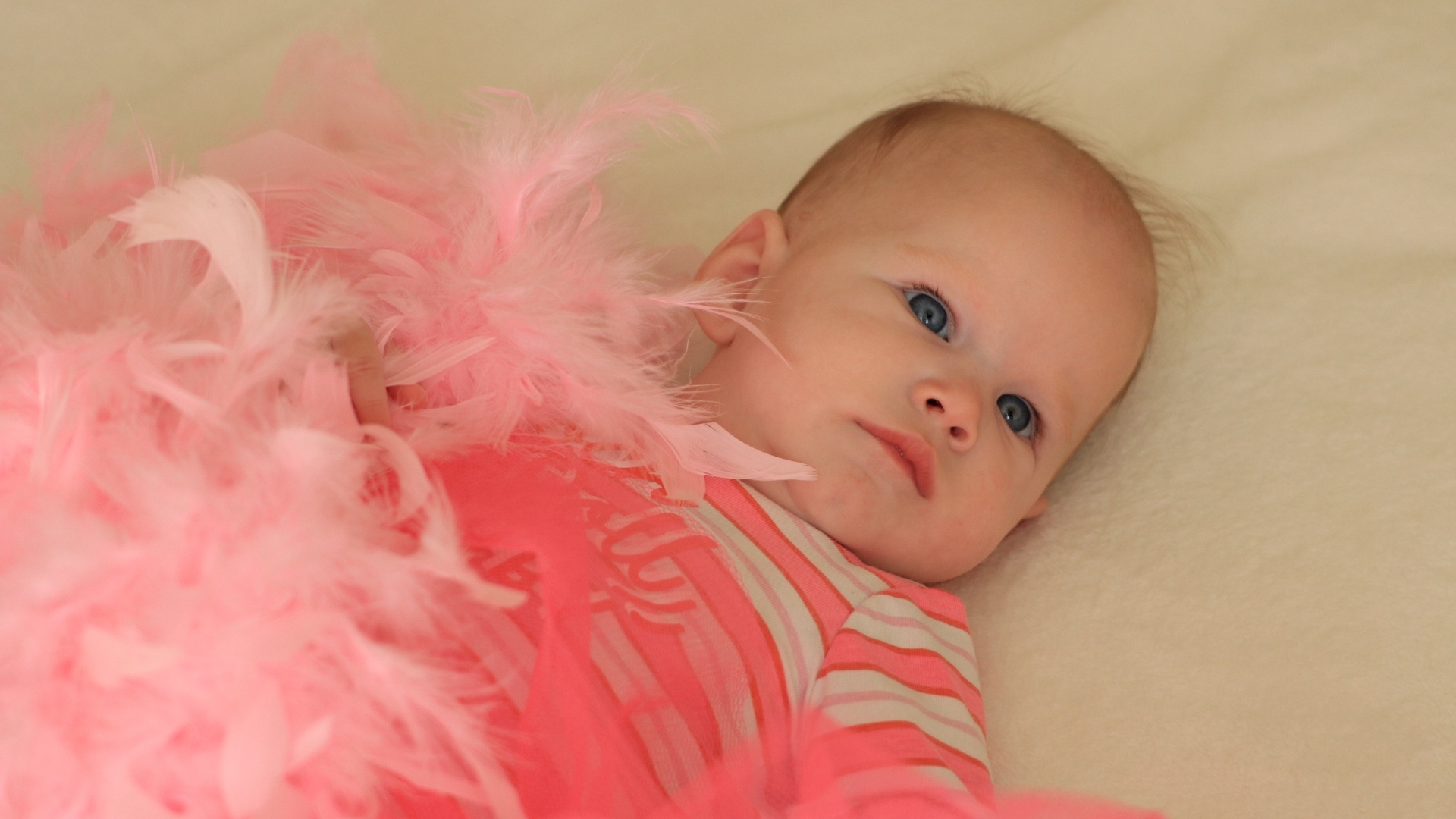 Милая малышка с розовыми перьями