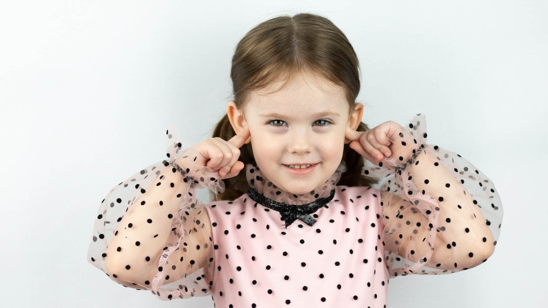 Смешная маленькая девочка закрыла уши