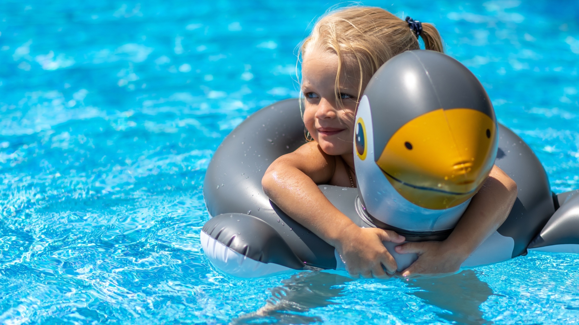 Девочка со спасательным кругом в бассейне