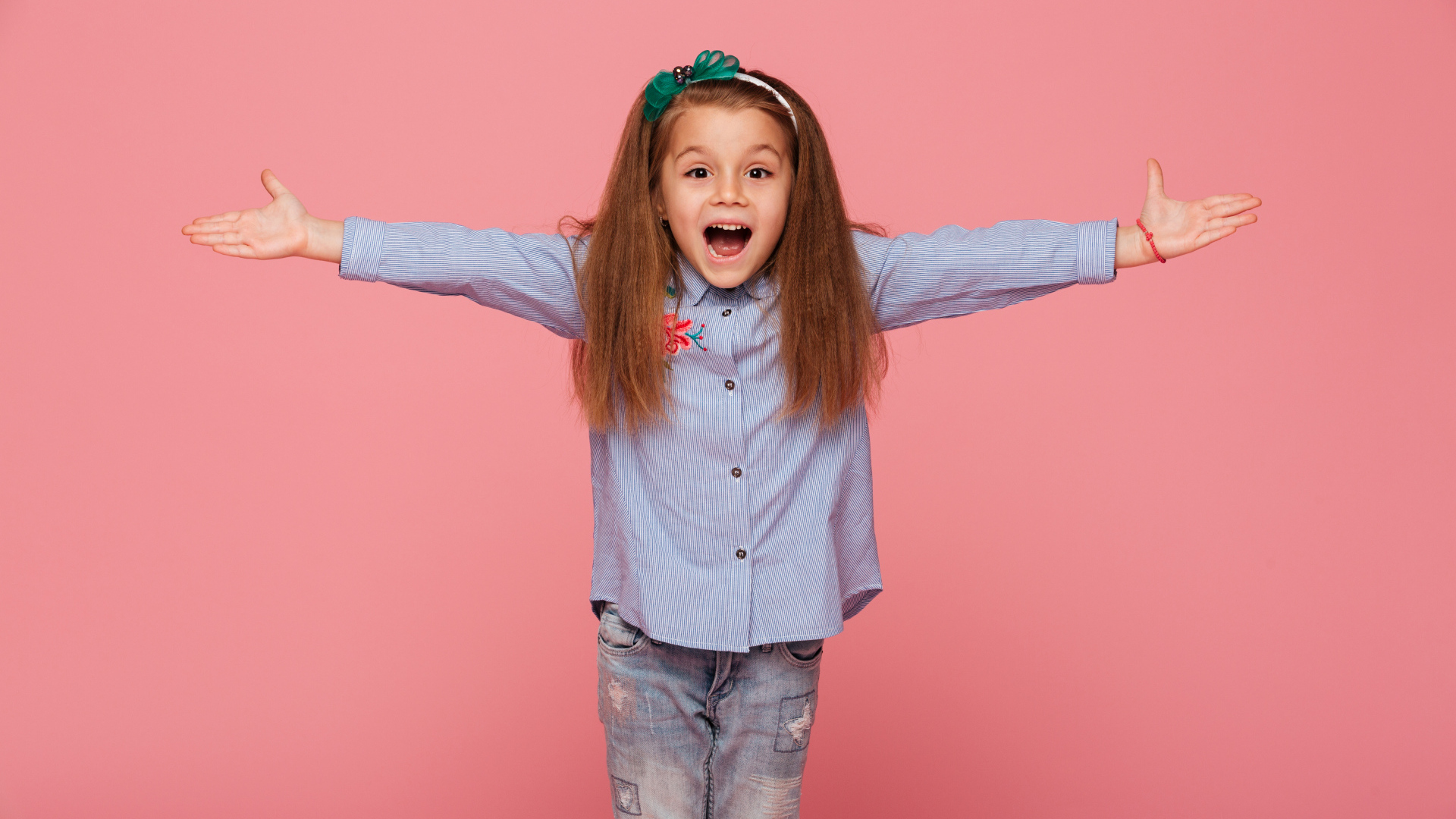 Счастливая маленькая девочка на розовом фоне