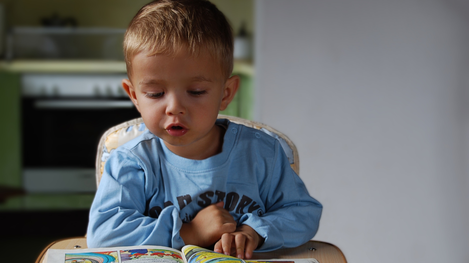 Маленький мальчик читает интересную книгу