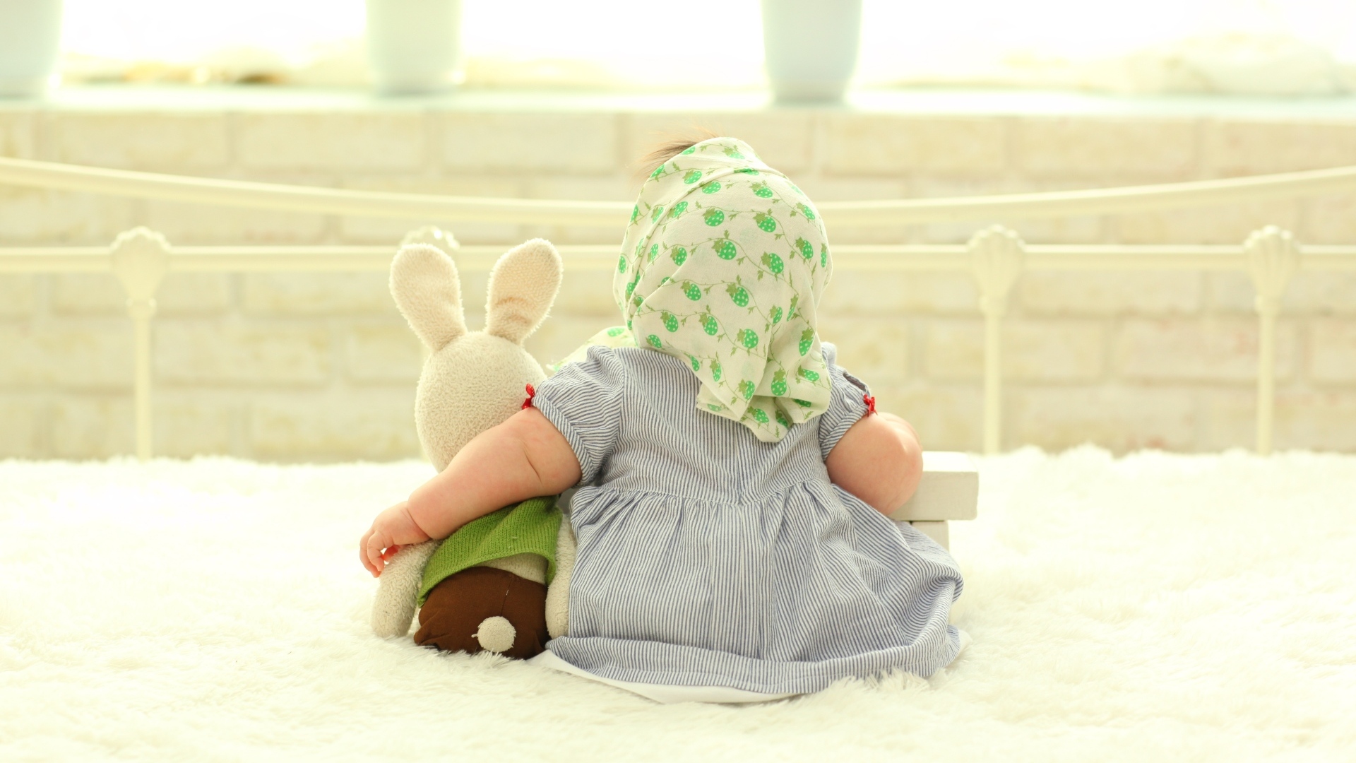 Маленькая девочка обнимает игрушечного зайца