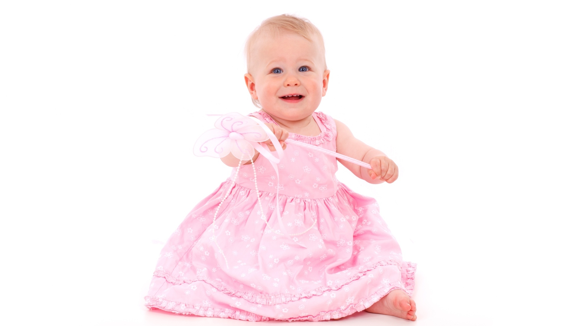 Маленькая девочка в розовом платье на белом фоне