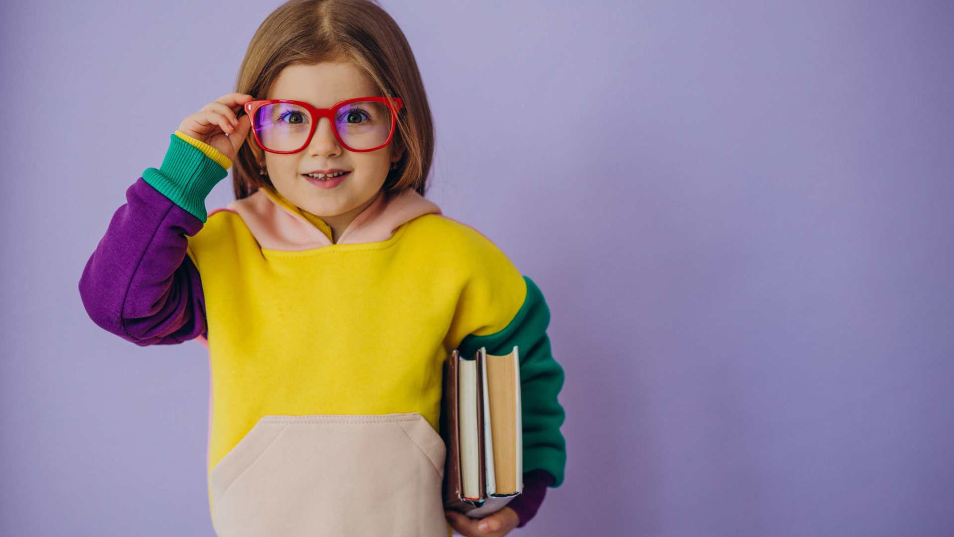 Маленькая девочка в очках с книгами в руке