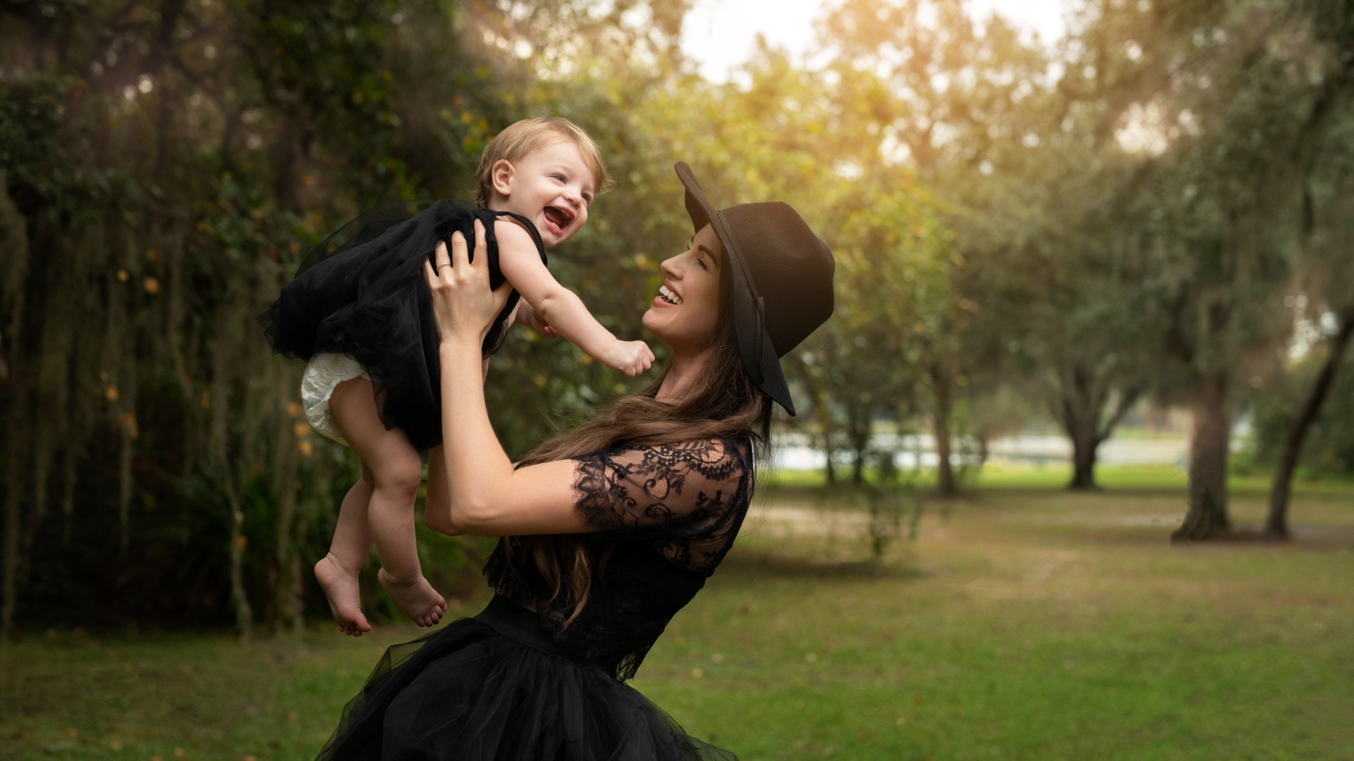 Мама держит улыбающуюся дочь на руках