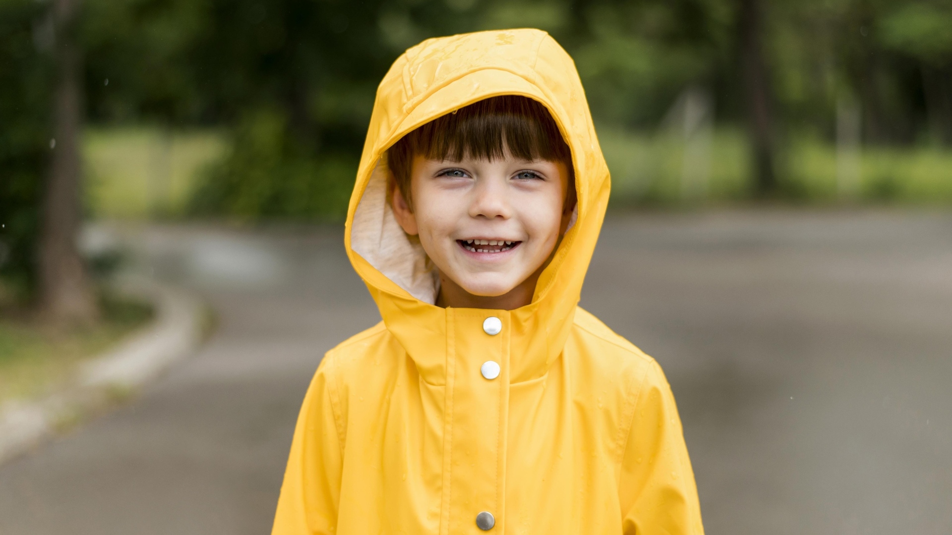 Улыбающийся мальчик в желтой куртке