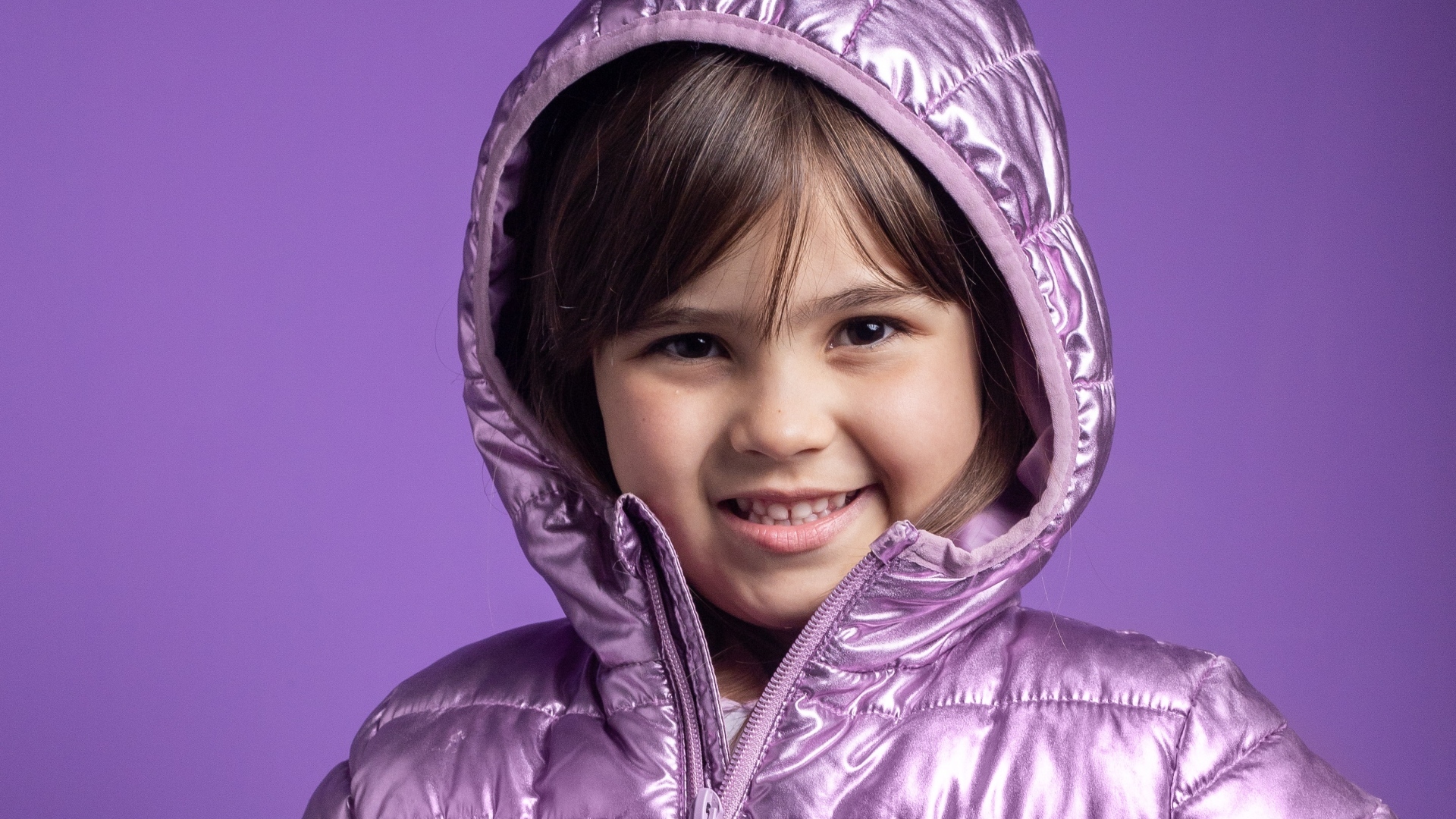 Улыбающаяся девочка в сиреневой куртке