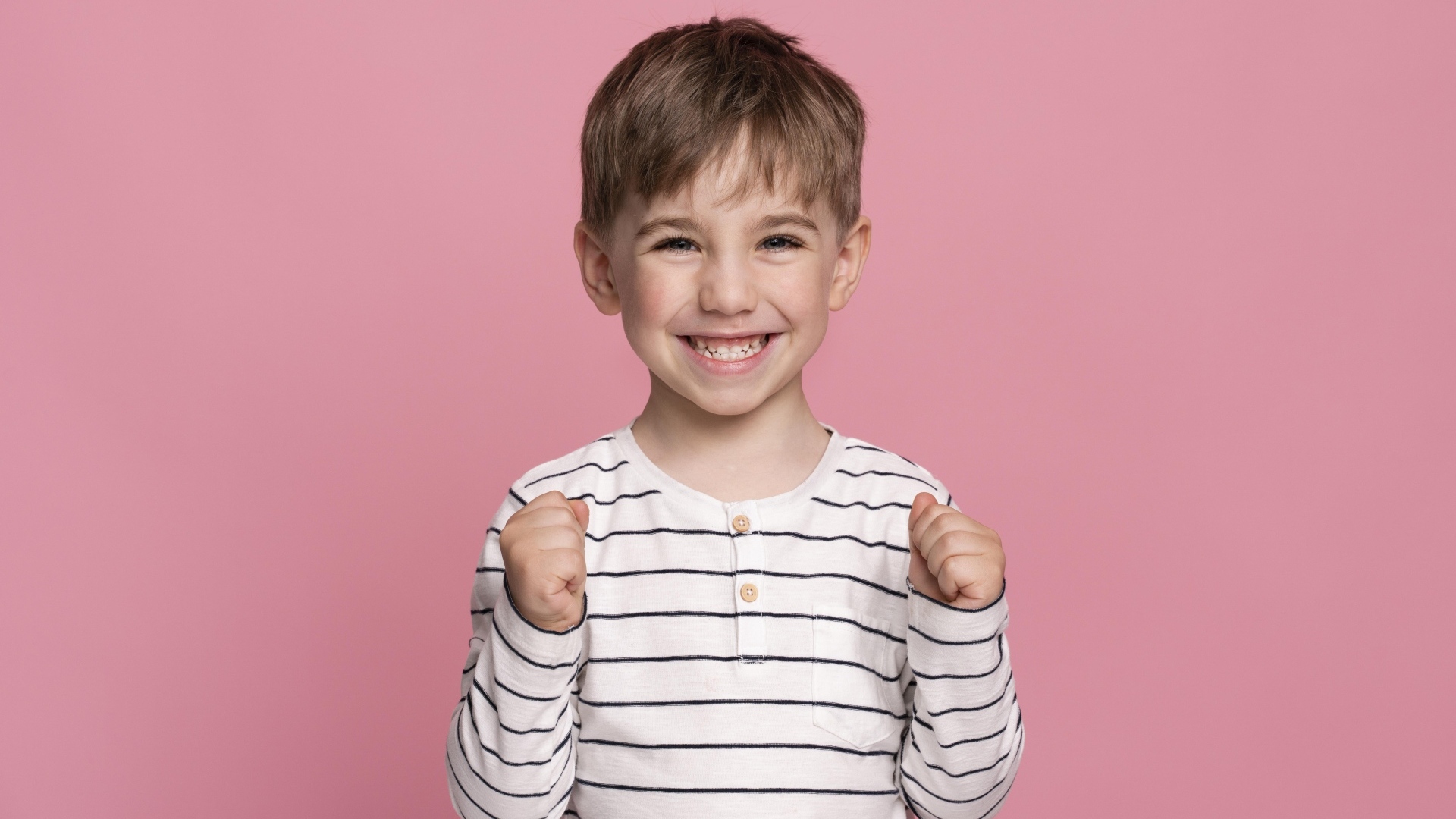 Улыбающийся маленький мальчик на сиреневом фоне