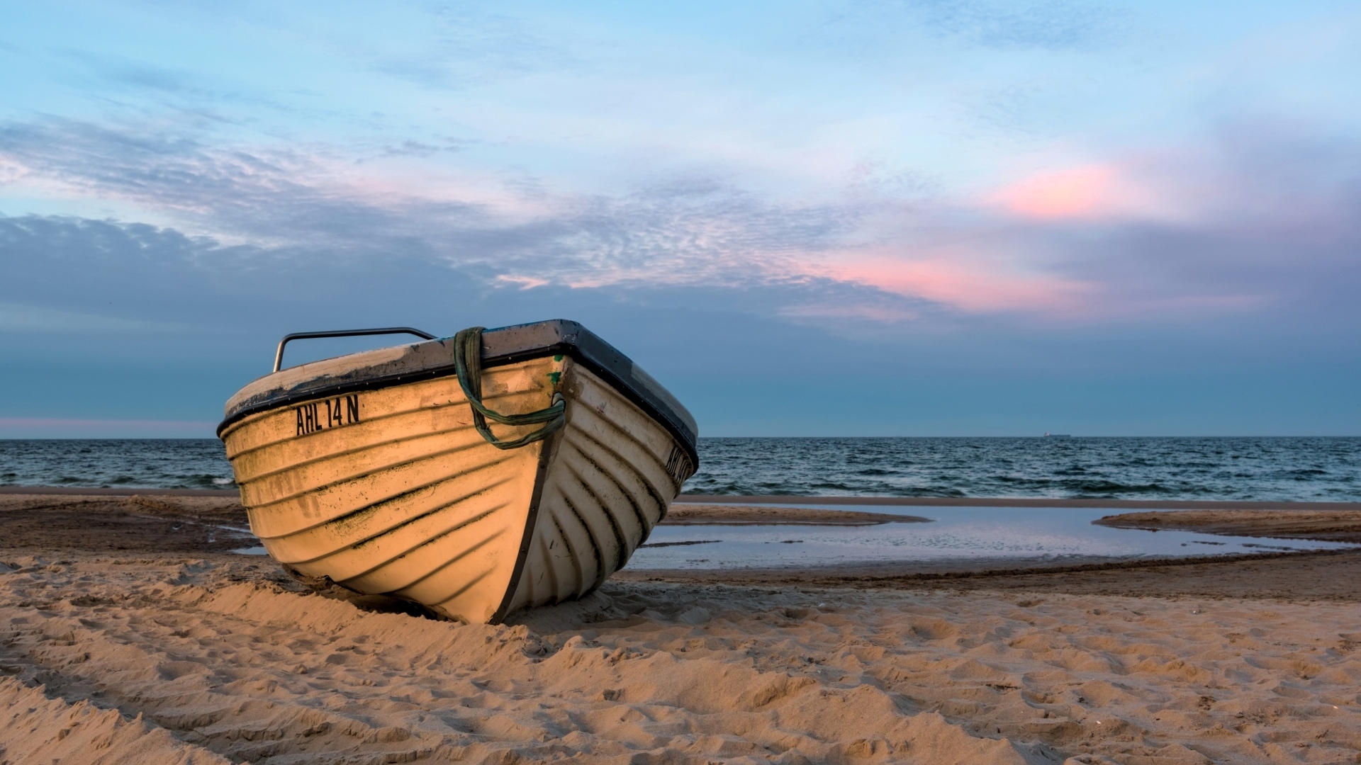 Лодка стоит на песке у моря летом